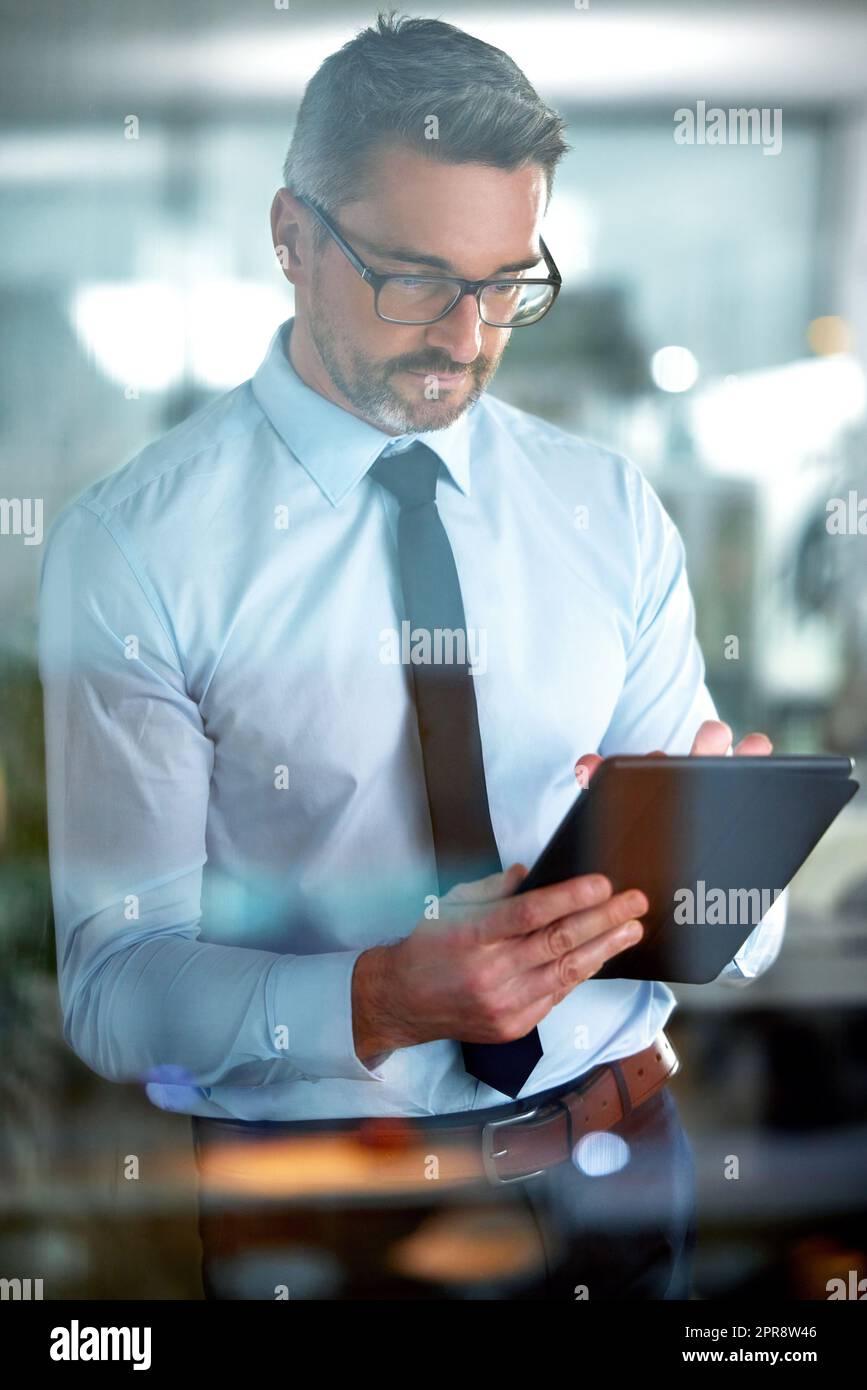 Es ist die Bereitschaft, Outwork und Outlearn jeder thatll machen Sie erfolgreich. Ein Geschäftsmann mit einem digitalen Tablet im Büro. Stockfoto