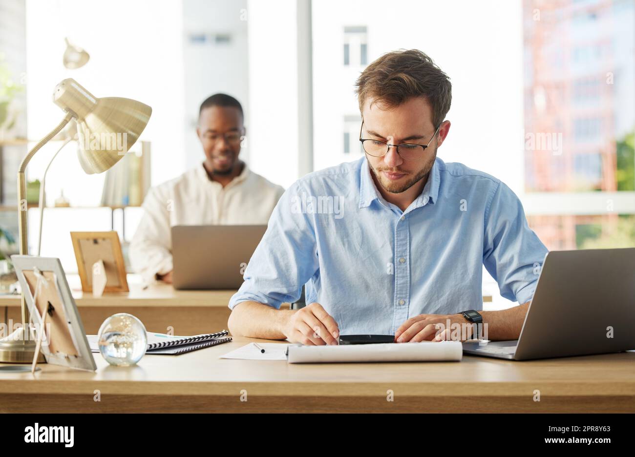 Ein junger, männlicher Geschäftsmann, der an seinen Finanzen arbeitet. Stockfoto