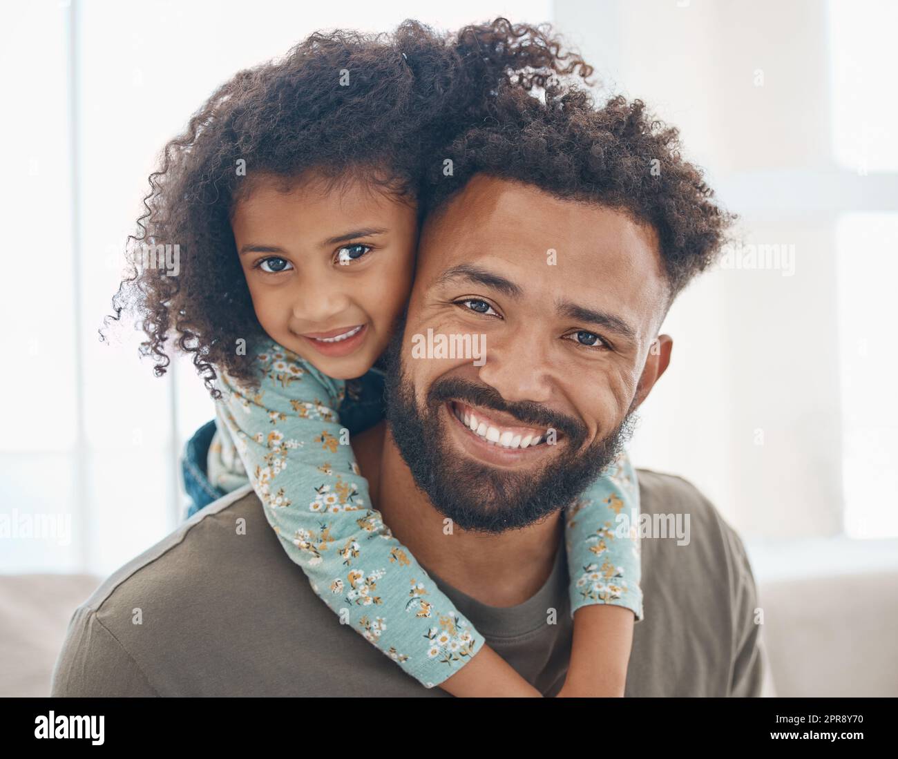 Eine glückliche Familie ist nur eine frühere Hebe. Ein Vater und seine kleine Tochter entspannen sich zu Hause. Stockfoto