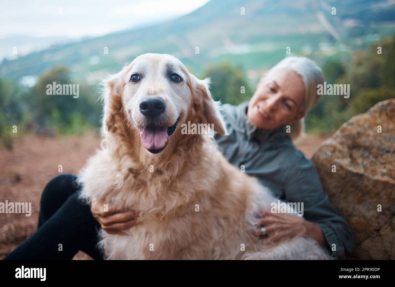 Ihn in meinem Leben zu haben hilft mir, aktiver zu sein. Eine ältere Frau macht mit ihrem Hund eine Wanderung. Stockfoto