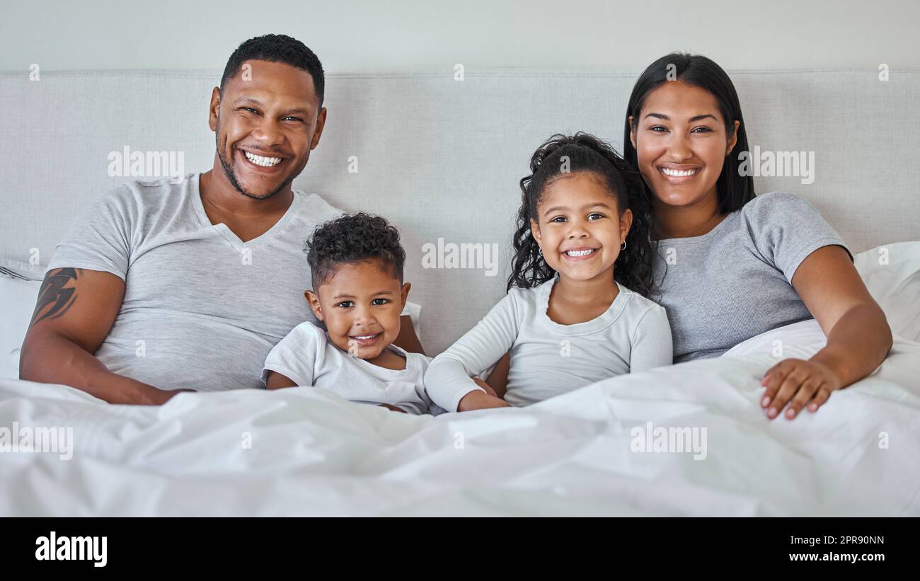 .. Eine schöne junge Familie, die im Bett miteinander redet und sich verbindet. Stockfoto