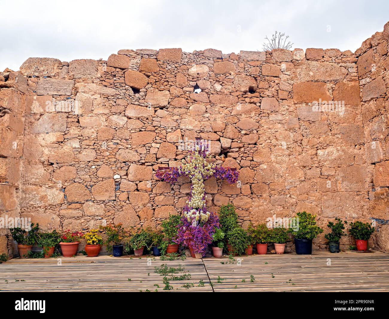 Antike Wand einer Kirchenruine auf Teneriffa, dekoriert mit Blumen- und Pflanzenkranz Stockfoto