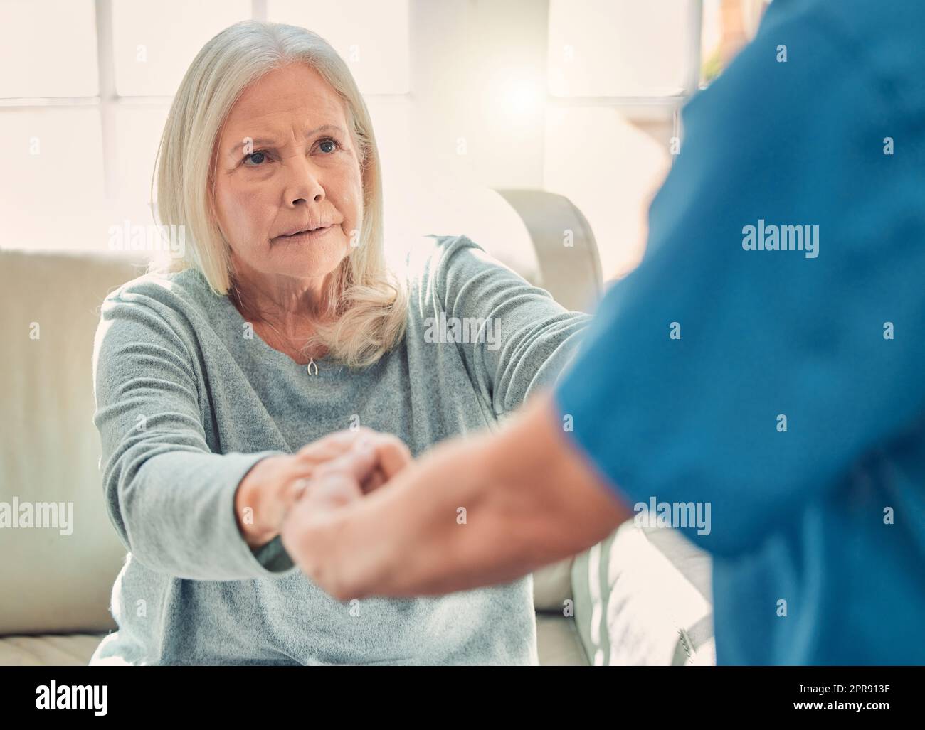 Mitgefühl ist der Wunsch, andere frei von Leiden zu sehen. Eine junge Krankenschwester hilft ihrer älteren Patientin Steh auf. Stockfoto