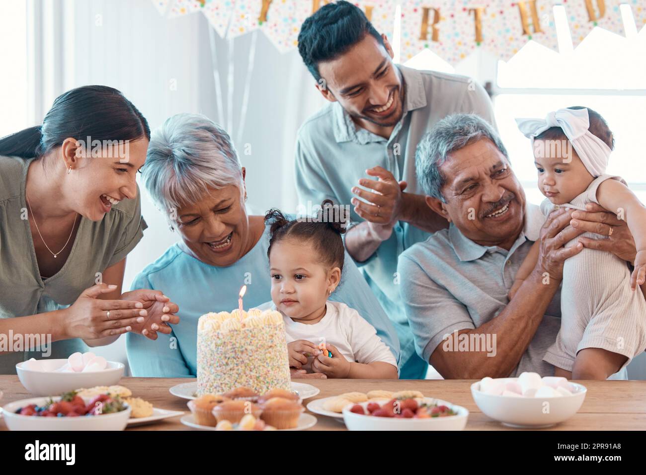 Sie will diesen Kuchen. Eine Familie, die zu Hause einen Geburtstag feiert. Stockfoto