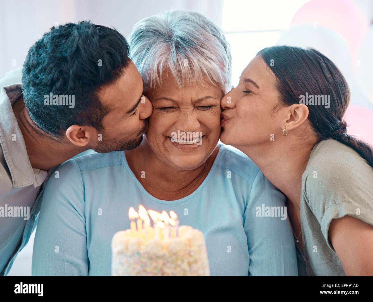 Unser Geschenk. Zwei junge Erwachsene feiern einen Geburtstag mit einer reifen Frau zu Hause