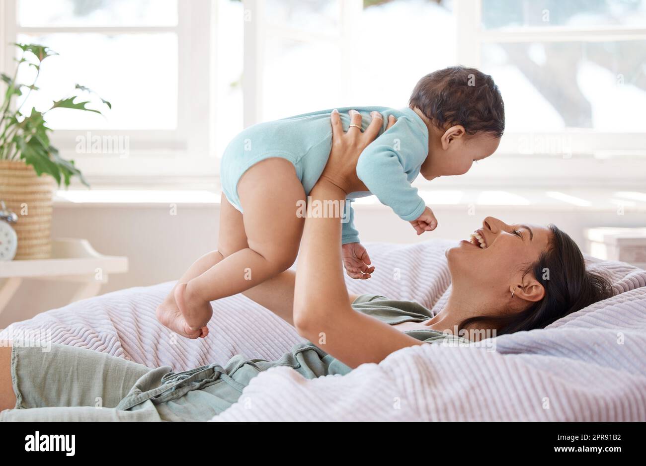 Wir machen lustige Dinge, wenn sie nicht nippen. Eine Mutter, die sich zu Hause mit ihrem Baby verbunden hat. Stockfoto