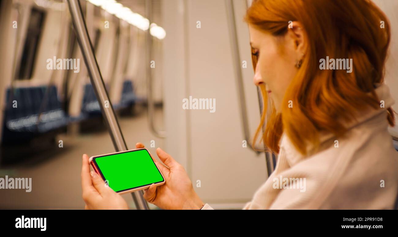 Horizontaler Green Screen Mock Up Smartphone Halten einer Frau, die sich ein Webinar zum Untertagebau ansieht. Stockfoto