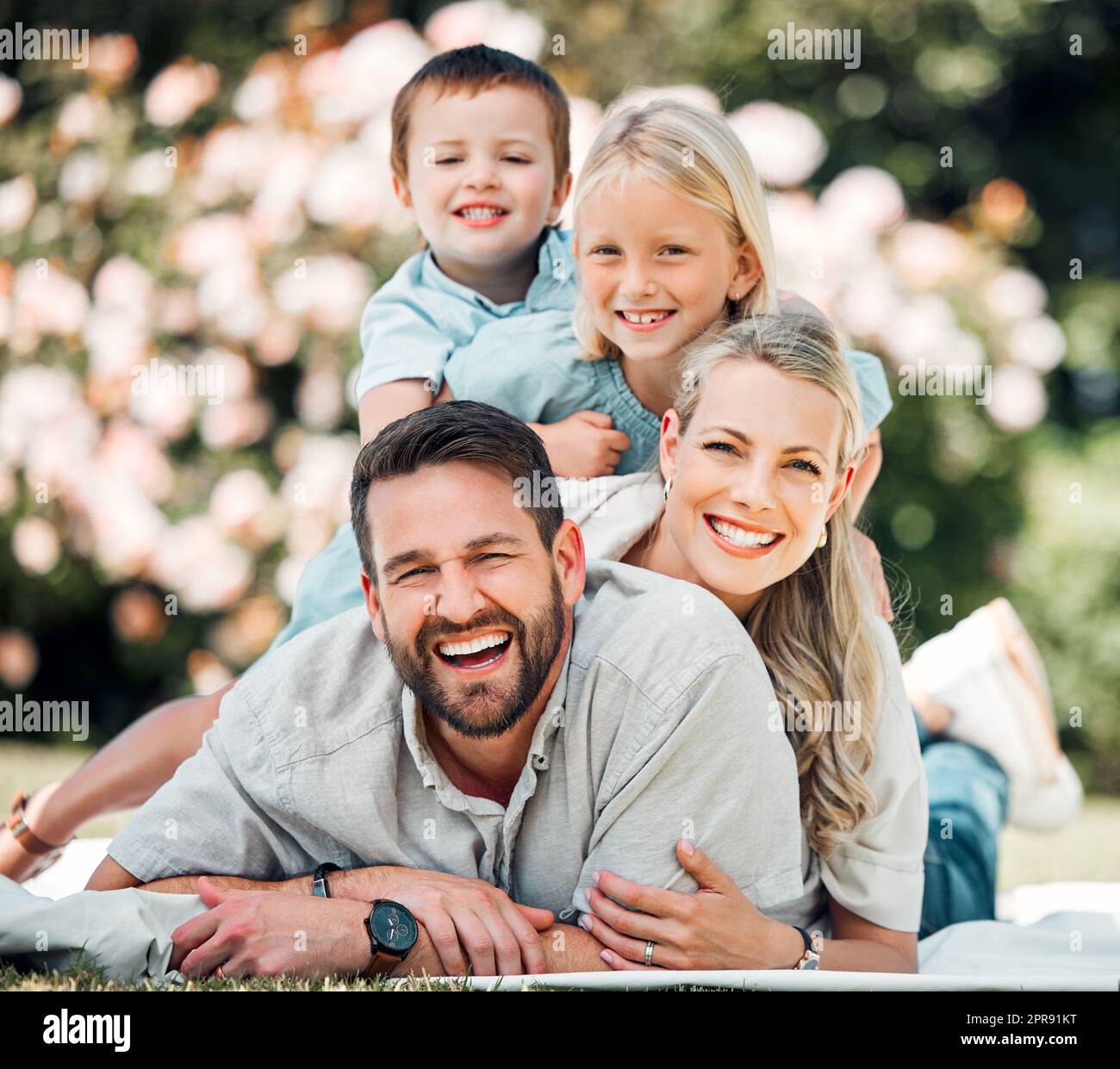 Sorgenfreie weiße Familie mit zwei Kindern, die Spaß im Freien haben ...