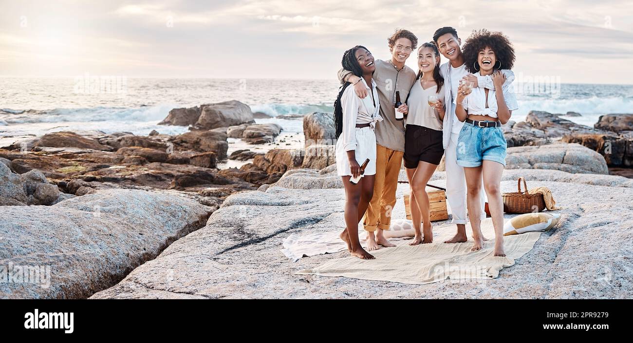 Eine Gruppe von Freunden genießt ihre Zeit zusammen und trinkt einige alkoholische Getränke am Strand Stockfoto