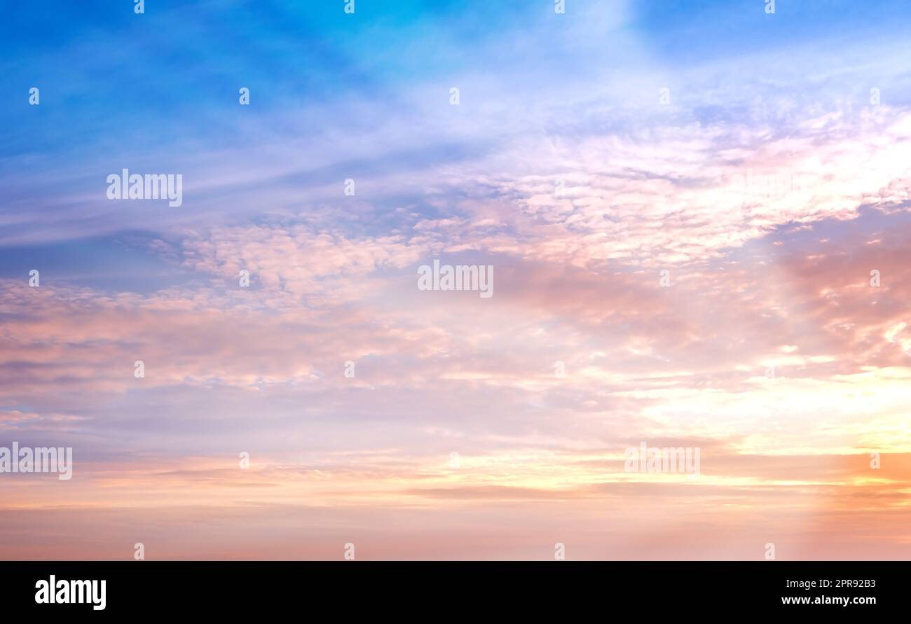 Kopieren Sie Raum und herrlicher Sonnenuntergang Himmel mit weichen Wolken und Sonnenstrahlen, die durch lebendige Farben mit Himmel und religiöser Theorie scheinen. Malerischer Blick auf friedliche, ruhige und ruhige Atmosphäre und Ozonschicht Stockfoto