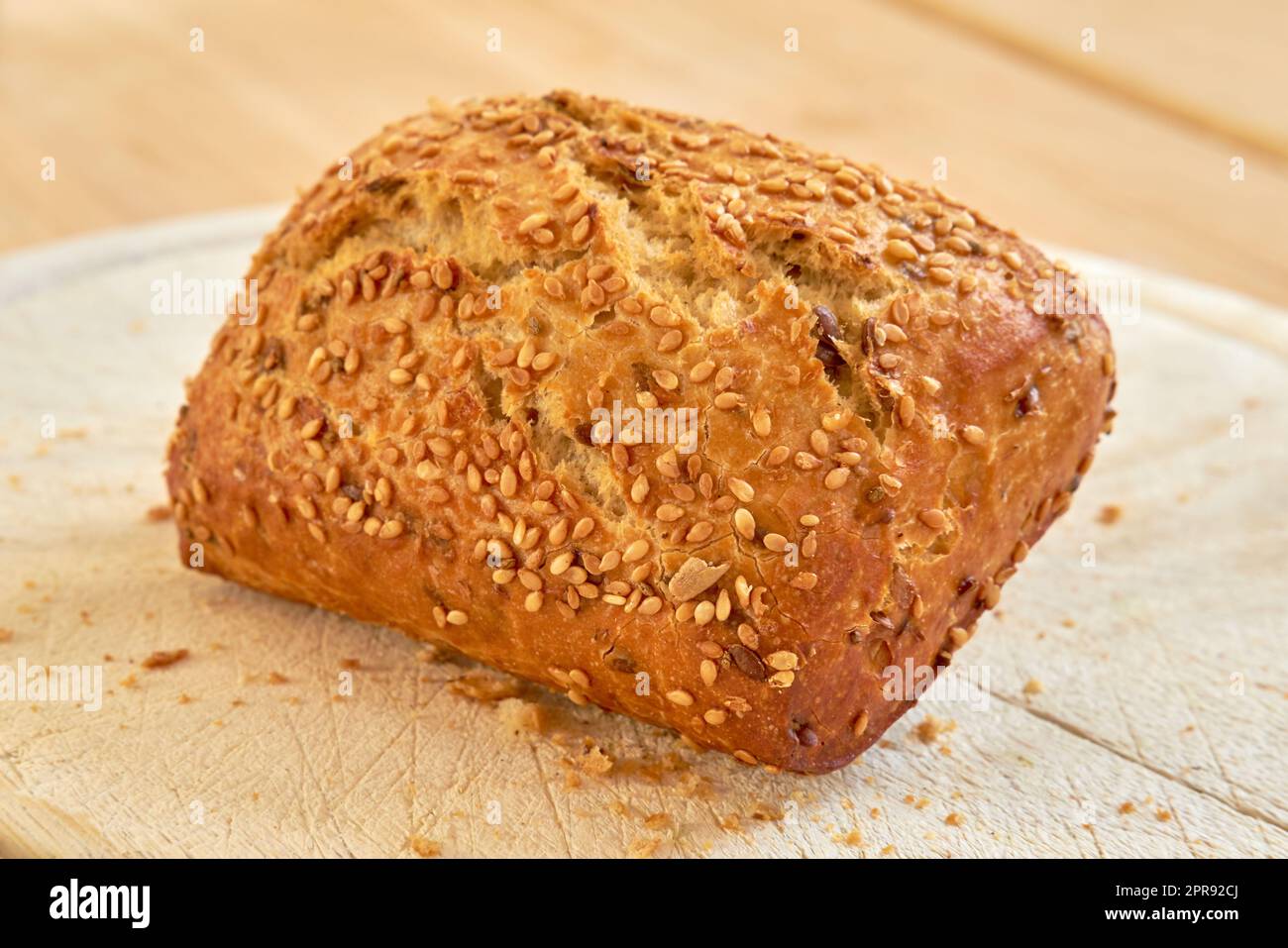 Frisch gebackenes Brot auf einem Tisch in einer Bäckerei oder Küche. Hausgemachtes Weizenbrötchen, frisch zubereitet von einem Ernährungsexperten, der biologisch angebaute, glutenfreie Brote backt, fertig zum Schneiden und als Mahlzeit serviert Stockfoto