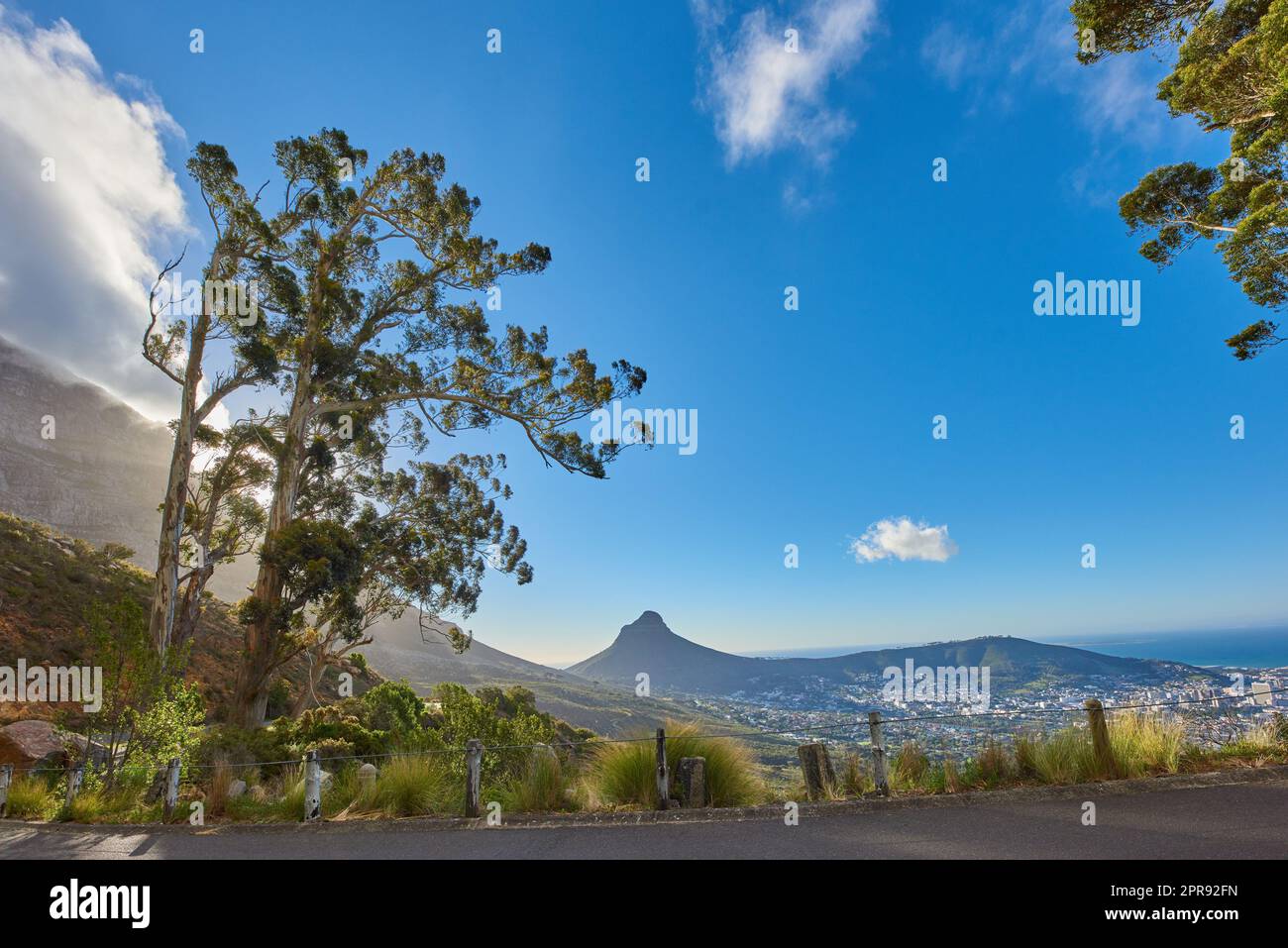 Straße oder Straße mit malerischem Bergblick und blauem Himmel während einer Sommerreise in Kapstadt, Südafrika. Landschaft mit üppigen grünen Hügeln und einem Bergpass für Wochenendausflüge und Fahrten Stockfoto