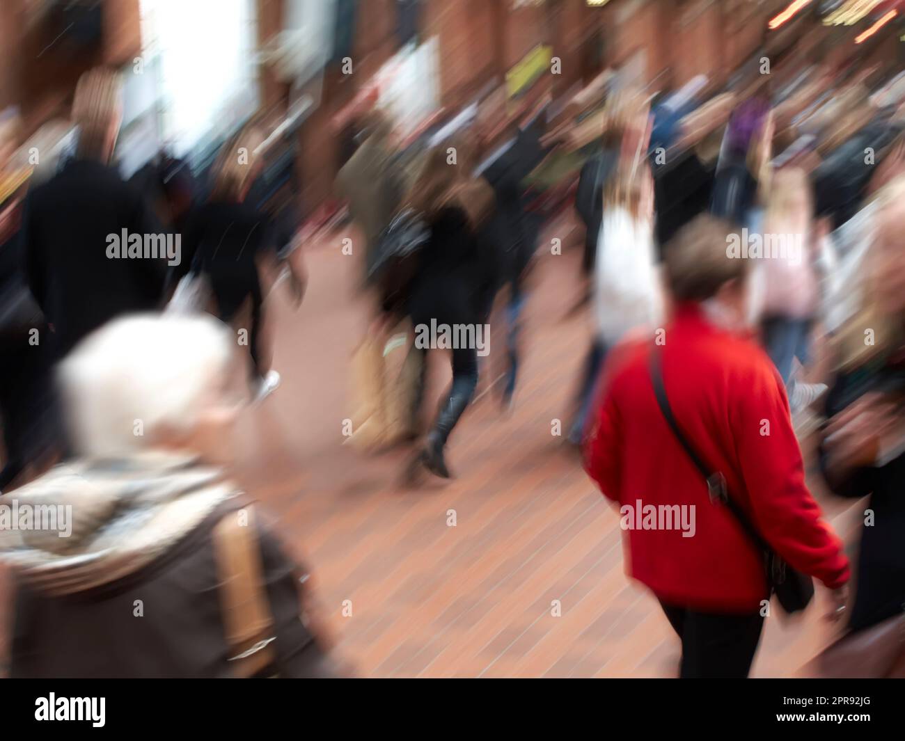 Eine Gruppe von Personen, die mit unscharfen Bewegungen durch städtische Straßen pendeln. Eine geschäftige Menschenmenge von Reisenden, die in einer Straße in der Stadt ankommen und zusammen spazieren. Viele Touristen in der Innenstadt Stockfoto