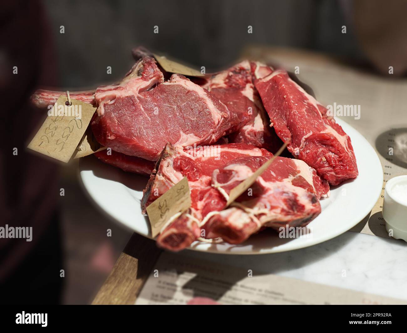 Draufsicht von Fleisch, das für den Verkauf bei einem Metzger vorbereitet wird. Köstliches Rindersteak, das verarbeitet und sortiert wird, um Mittag- oder Abendessen in einer Küche zu Hause zuzubereiten. Lebensmittel mit hohem Proteingehalt, frisch von einem Bauernhof Stockfoto