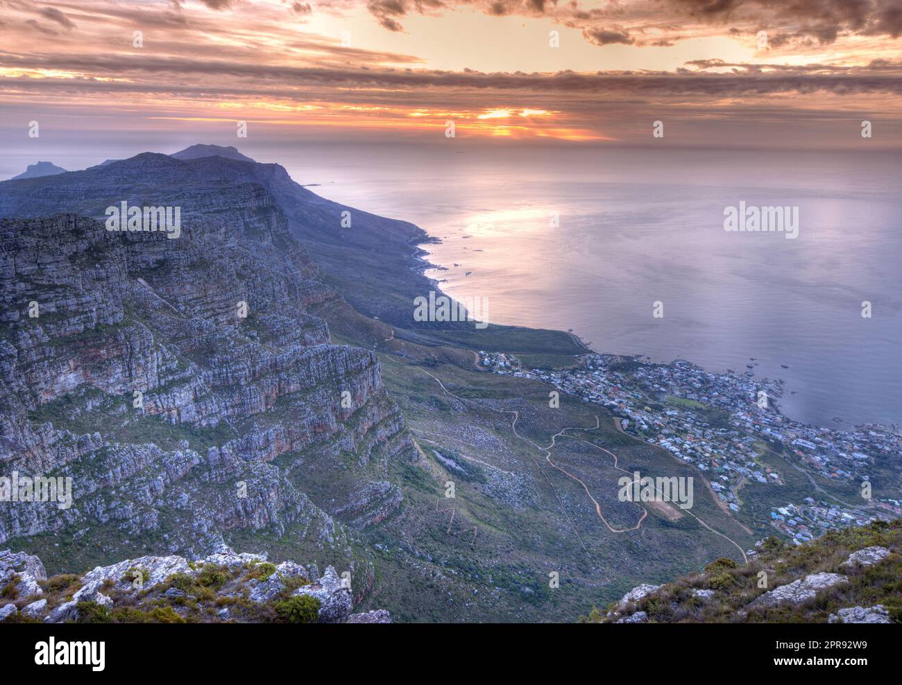 Wunderschöner Blick auf ein Wahrzeichen und berühmtes Reise- oder Urlaubsziel, um die Natur in Südafrika zu erkunden. Luftaufnahme auf das Meer und den Tafelberg an einem bewölkten Tag bei Sonnenuntergang mit Kopierbereich. Stockfoto