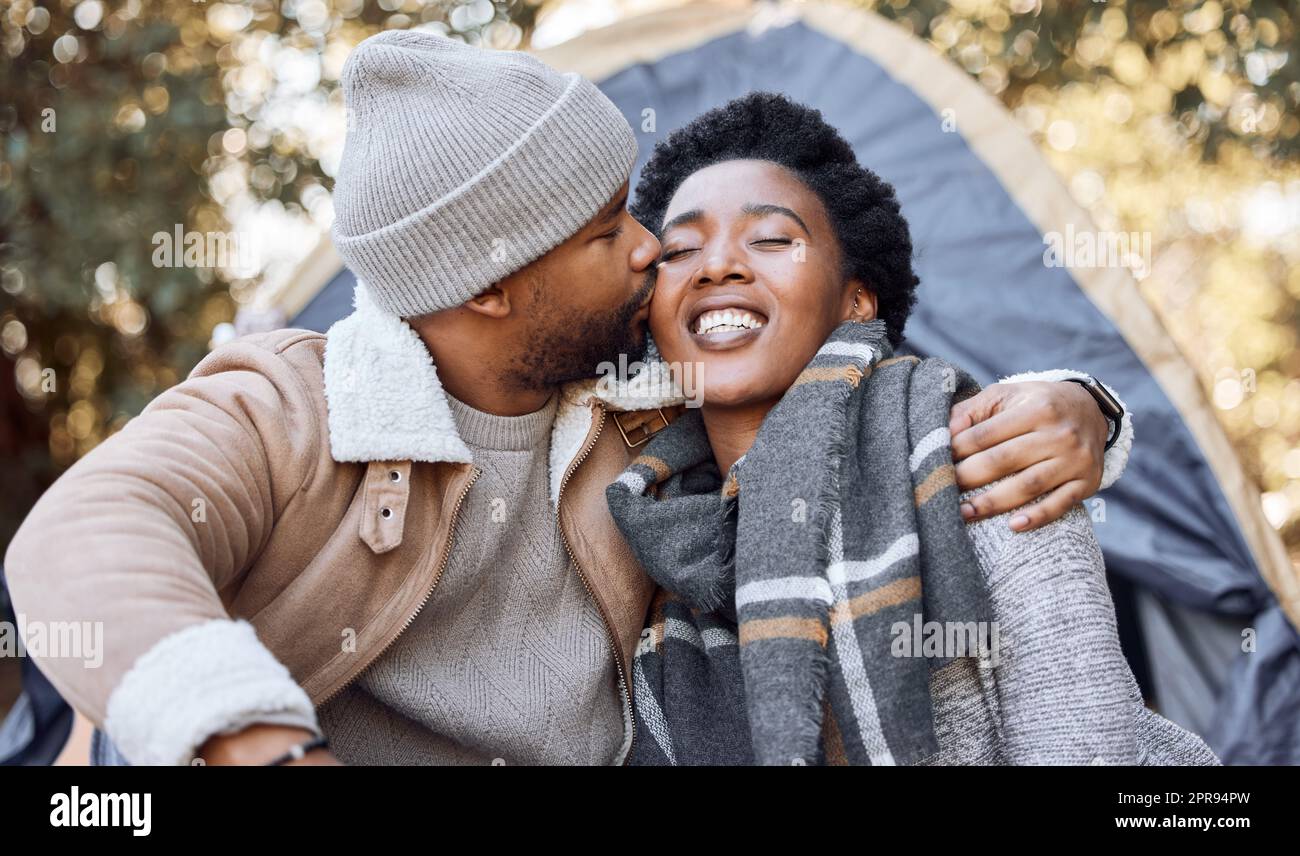 Wir sollten das öfter tun. Ein junger Mann küsst seine Freundin während eines Campingausflugs. Stockfoto