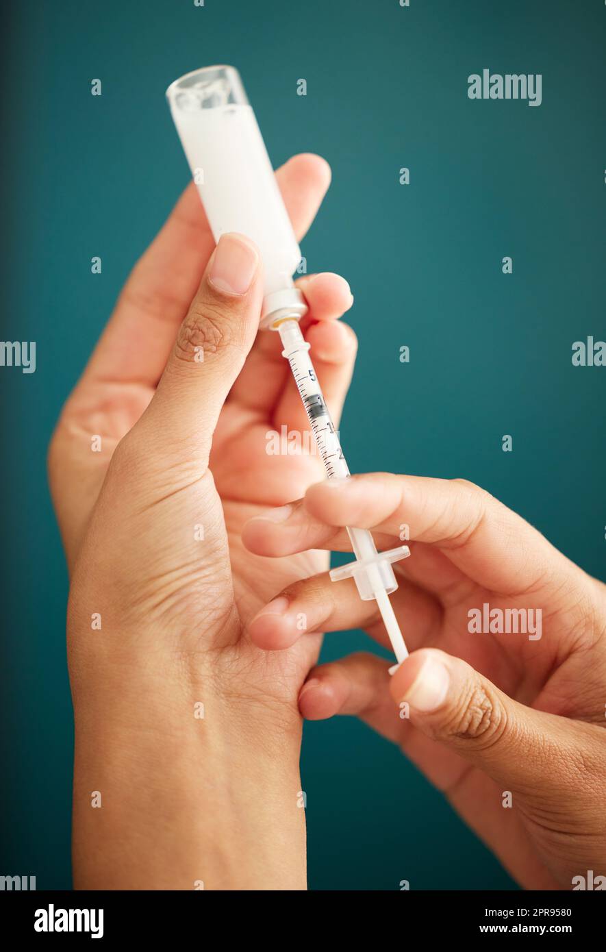 Insulin ist die natürliche Anforderung. Eine unkenntliche Frau, die zu Hause eine Dosis Insulin in eine Spritze zieht. Stockfoto