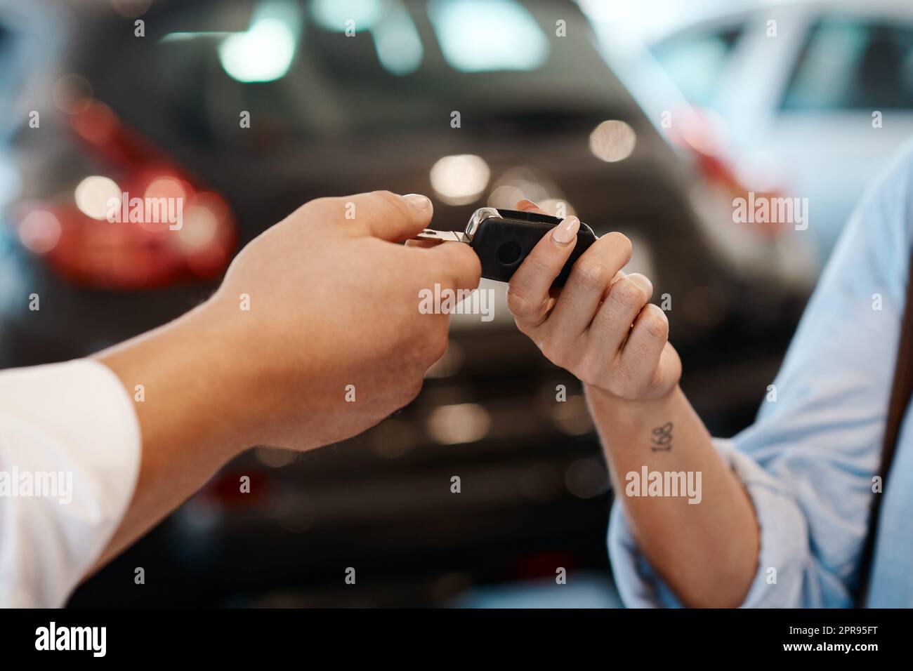 Willkommen in Ihrem neuen Leben. Ein Autoverkäufer, der Schlüssel an einen Kunden übergibt. Stockfoto