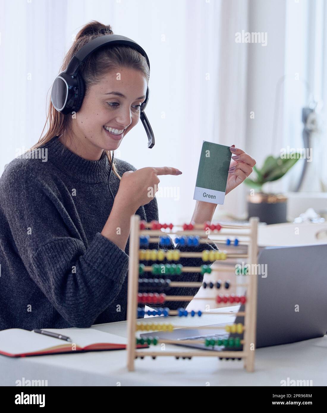 Jeder, der sich an seine eigene Ausbildung erinnert, erinnert sich an Lehrer. Eine junge Lehrerin, die zu Hause mit ihrem Laptop einen Online-Unterricht unterrichtet. Stockfoto