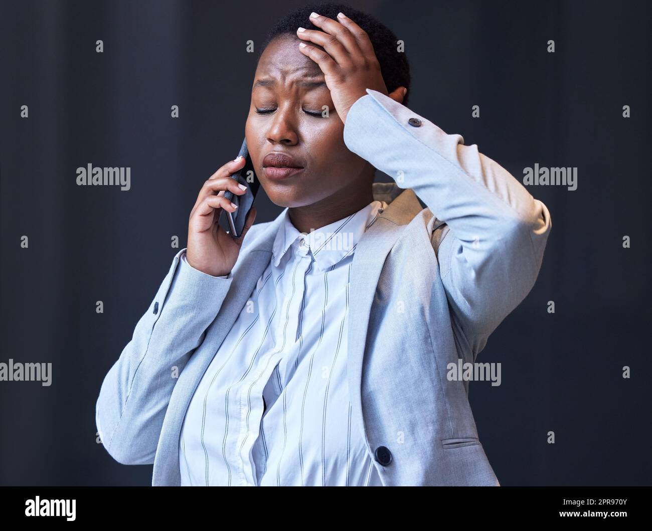 Entschuldigen Sie sich nie. Eine junge Frau, die ihr Handy bei der Arbeit benutzt. Stockfoto
