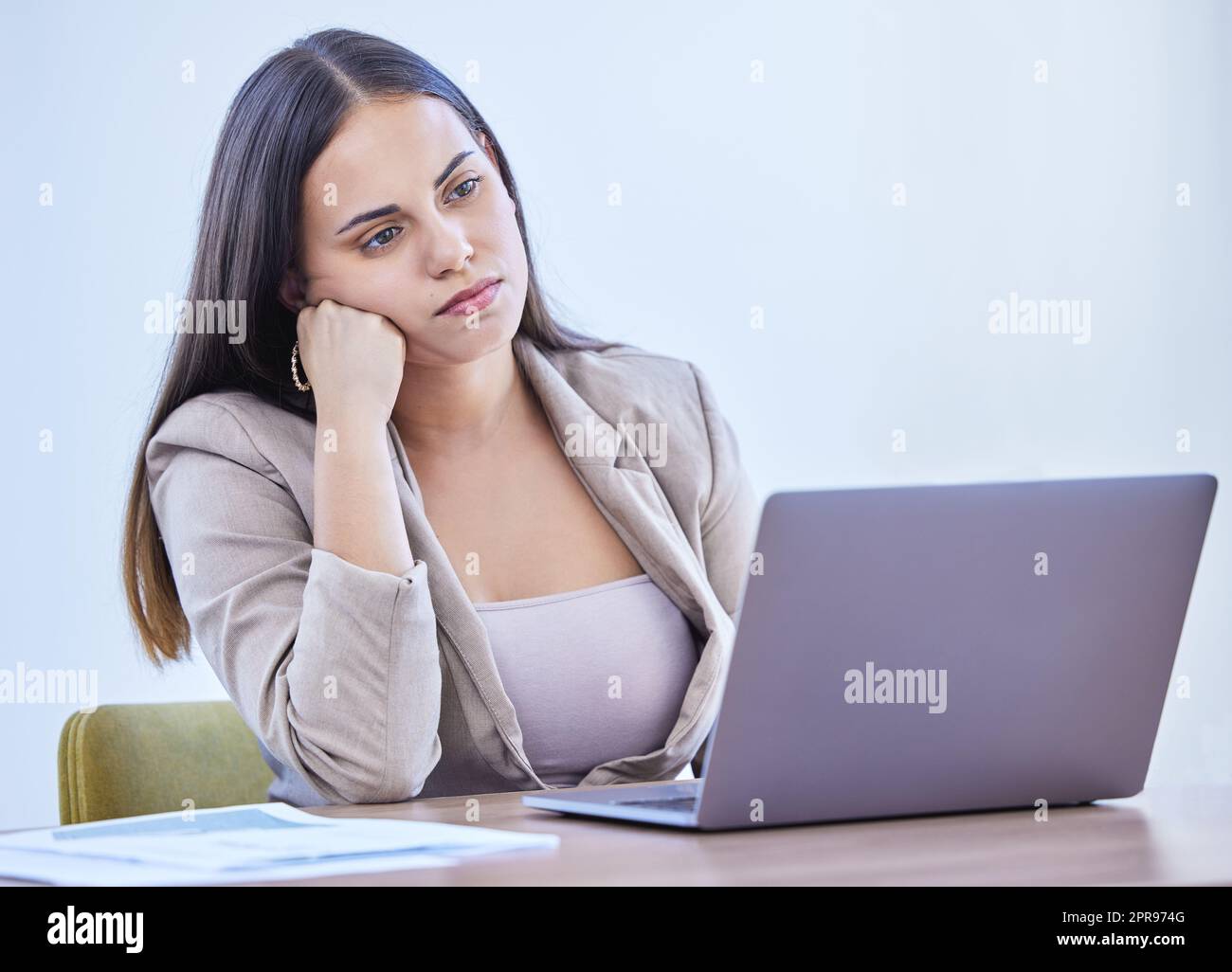 In einem Einbruch und mangelnder Motivation. Eine junge Geschäftsfrau, die sich langweilen sieht, während sie in einem Büro arbeitet. Stockfoto