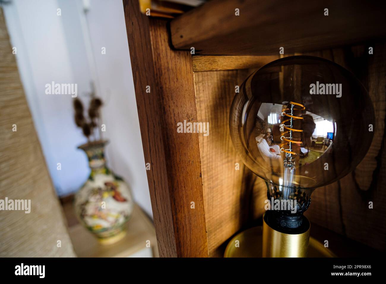 Alte Glühlampe Dekorationsleuchte mit Holzmöbeln im Innenraum Stockfoto