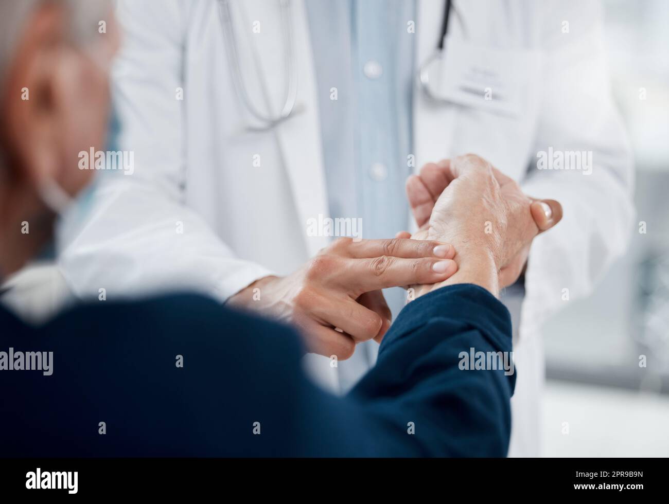 Ihr Puls scheint normal zu sein. Ein nicht erkennbarer Arzt, der den Puls eines Patienten in einem Büro überprüft. Stockfoto