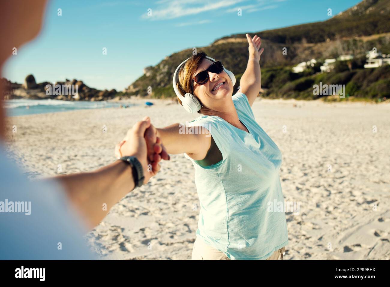 Jetzt ist die Zeit, um Ihr bestes Leben zu leben. Eine Frau, die Kopfhörer trägt und sich am Strand amüsiert. Stockfoto