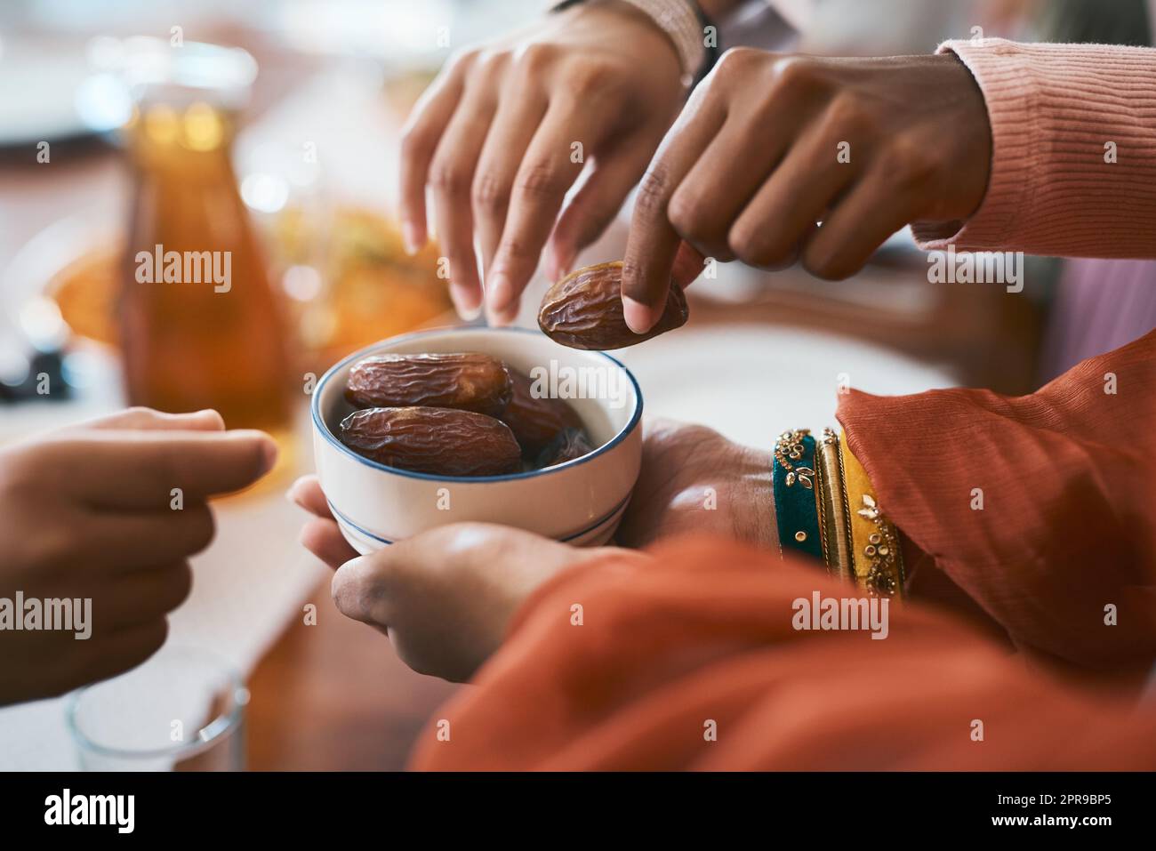 Zeit, unser Fasten zu brechen. Eine muslimische Familie bricht ihr Fasten mit Daten. Stockfoto
