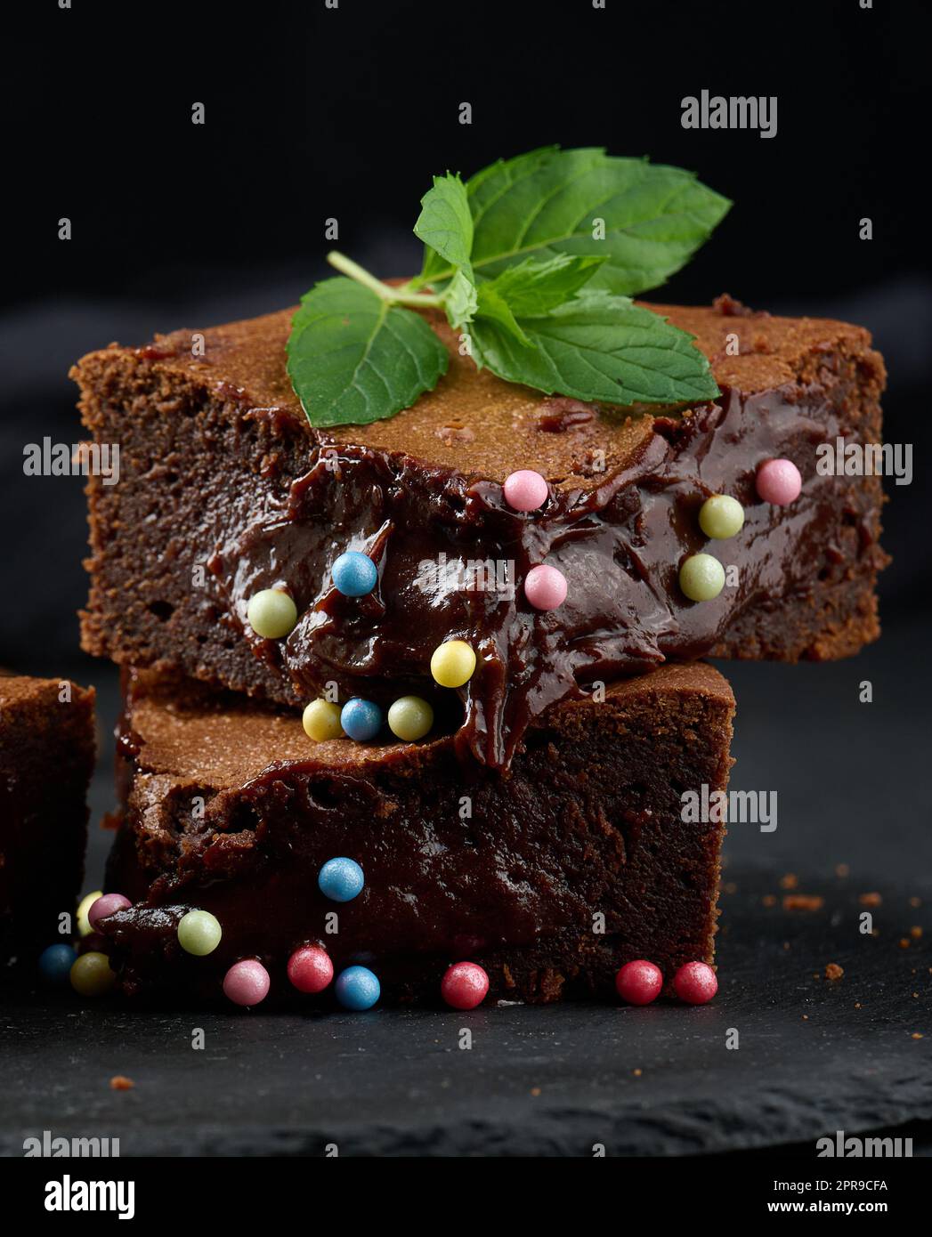 Gebackene Brownie-Schokoladenstückchen auf einem schwarzen Tisch Stockfoto
