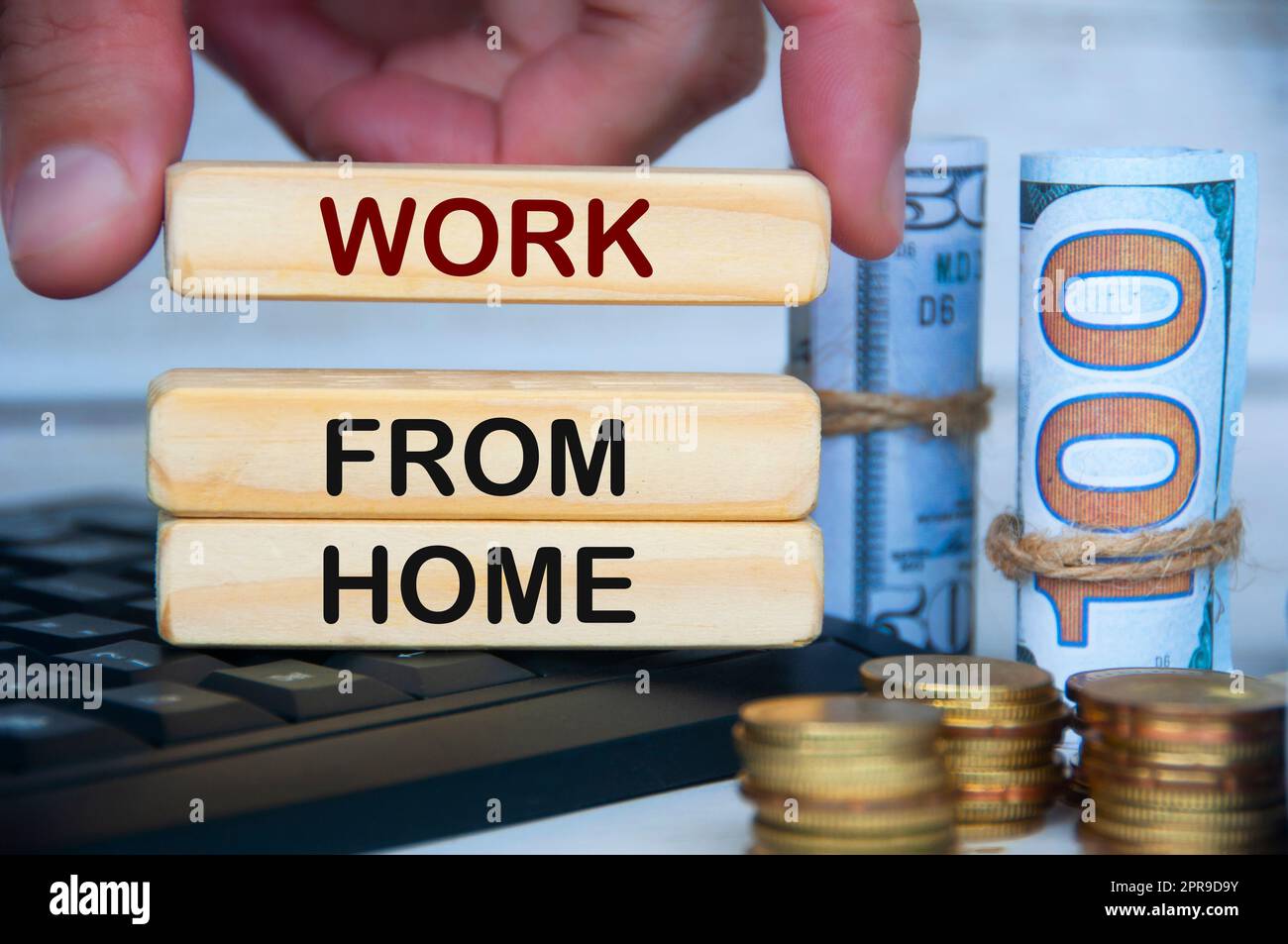 Handarbeit von zu Hause aus Text auf Holzblöcken auf dem Tastaturcomputer mit Goldmünzen und Banknoten. Stockfoto