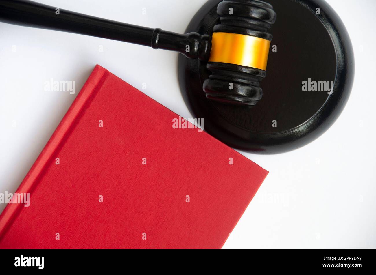 Rotes Umschlagsbuch und Hammer mit Platz, der für Text oder Ideen angepasst werden kann. Regelkonzept Stockfoto