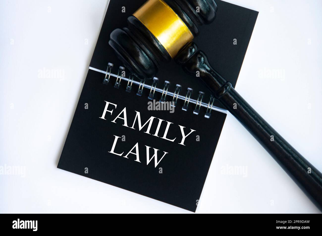 Draufsicht des Familientextes auf schwarzem Notizblock mit Hammer auf weißem Hintergrund. Familienrechtsbegriff. Stockfoto