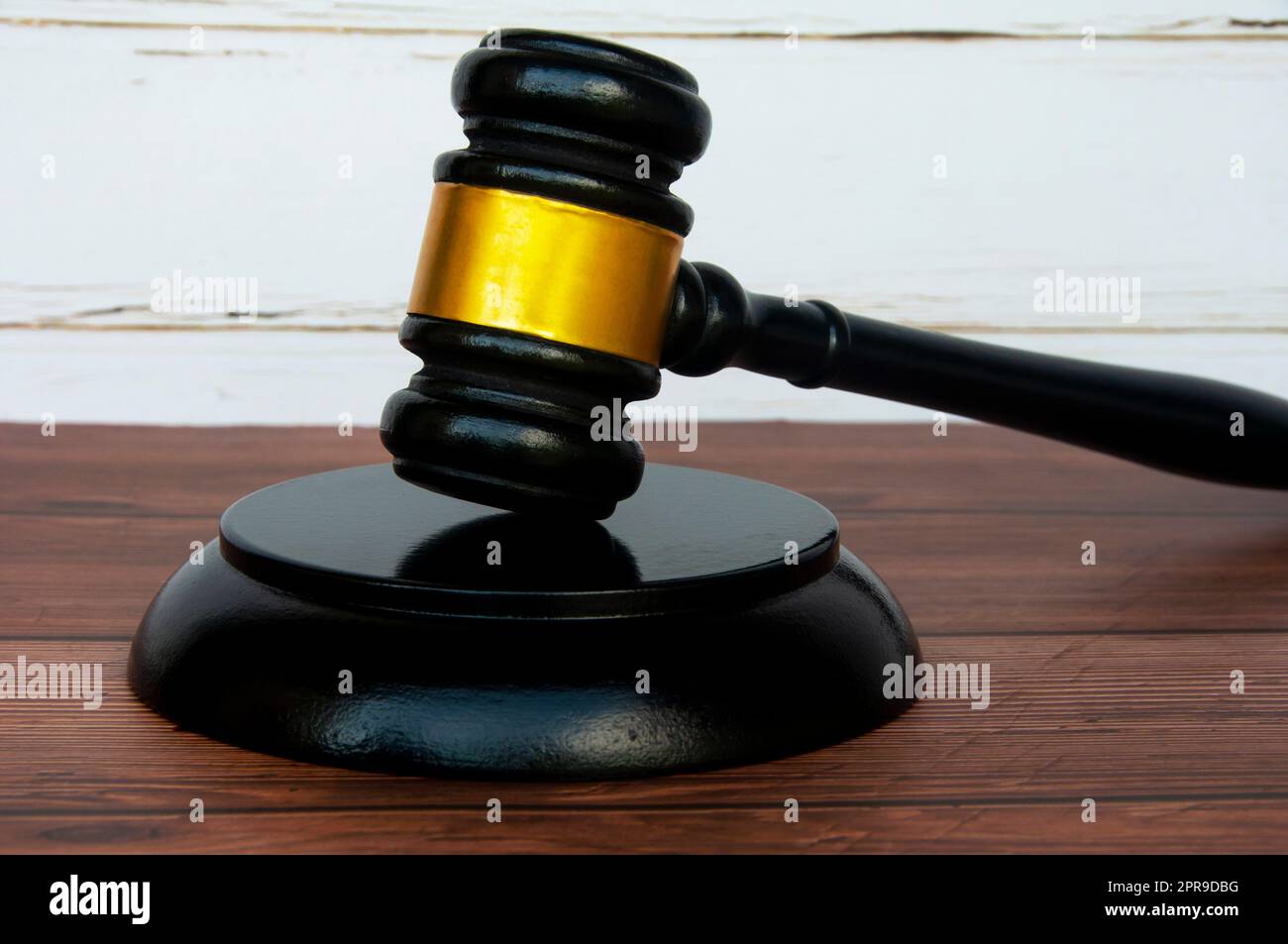 Seitenansicht des Hammers auf Tischhintergrund aus Holz. Regelkonzept. Stockfoto