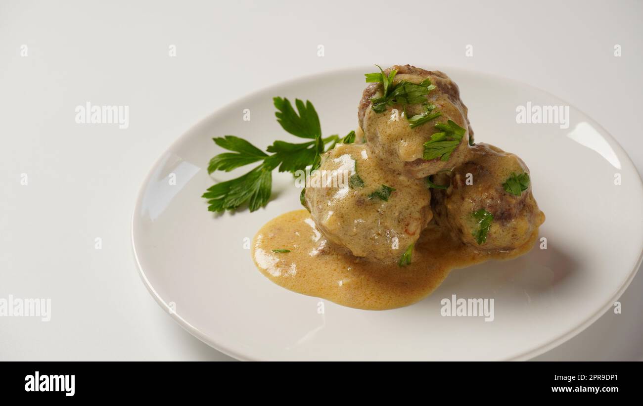 Ein Teller mit schwedischen Fleischbällchen in Rahmsauce mit Kartoffelpüree. Stockfoto