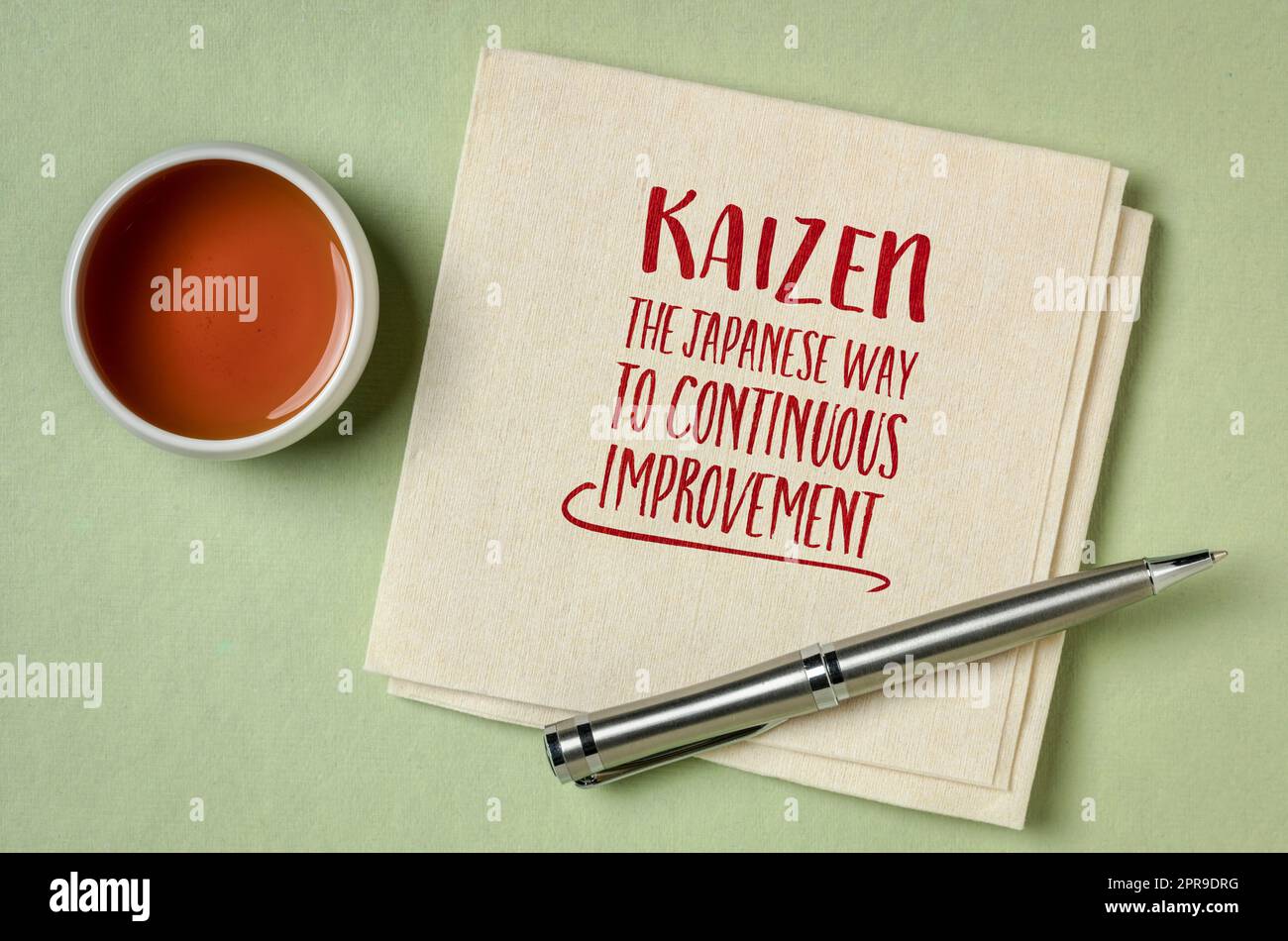 kaizen - Japanisches Konzept der kontinuierlichen Verbesserung, inspirierende Note auf einer Serviette mit Tee, geschäftlicher und persönlicher Entwicklung Stockfoto