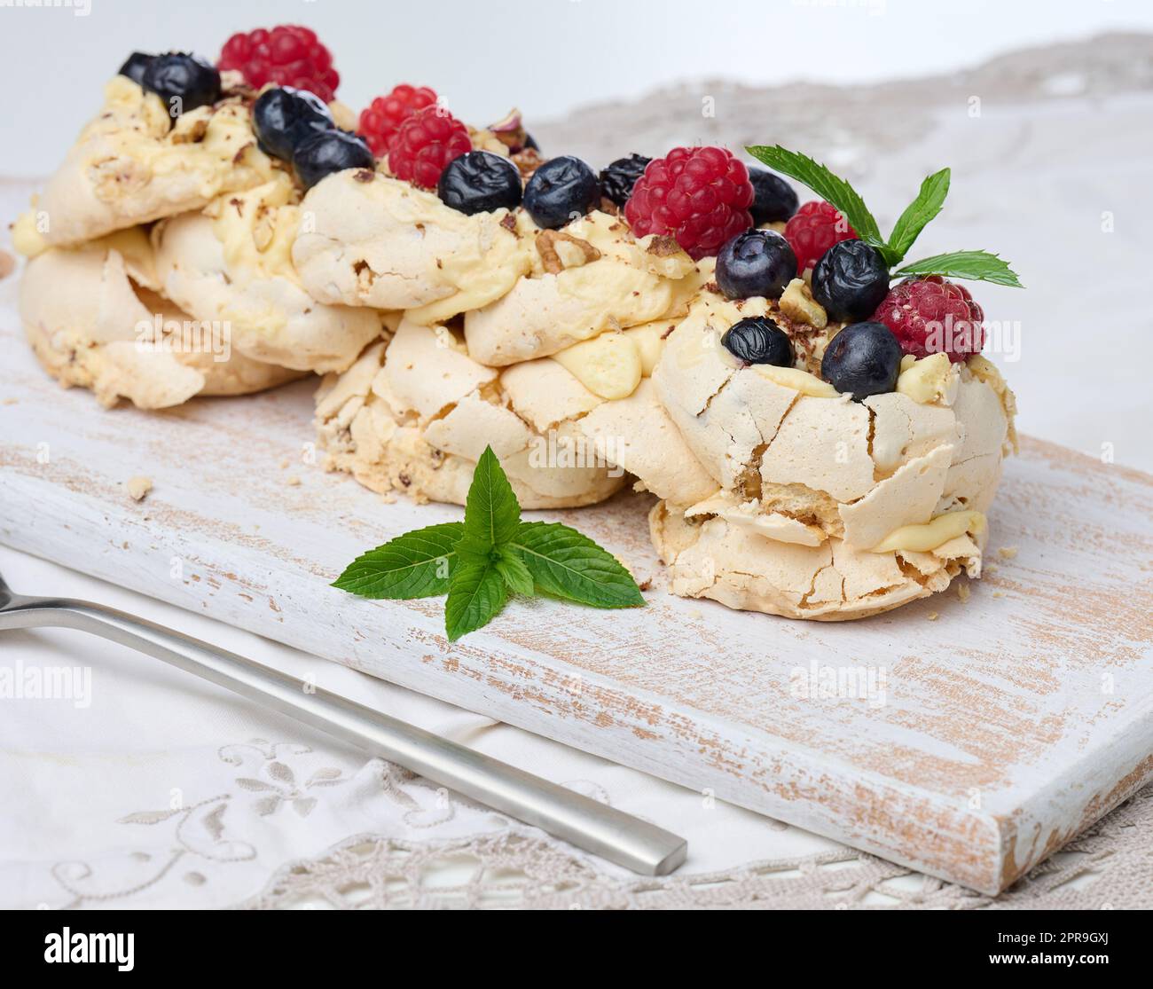 Gebackener Kuchen aus geschlagenen Hühnerproteinen und Rahm, verziert mit frischen Beeren. Dessert Pavlova Stockfoto