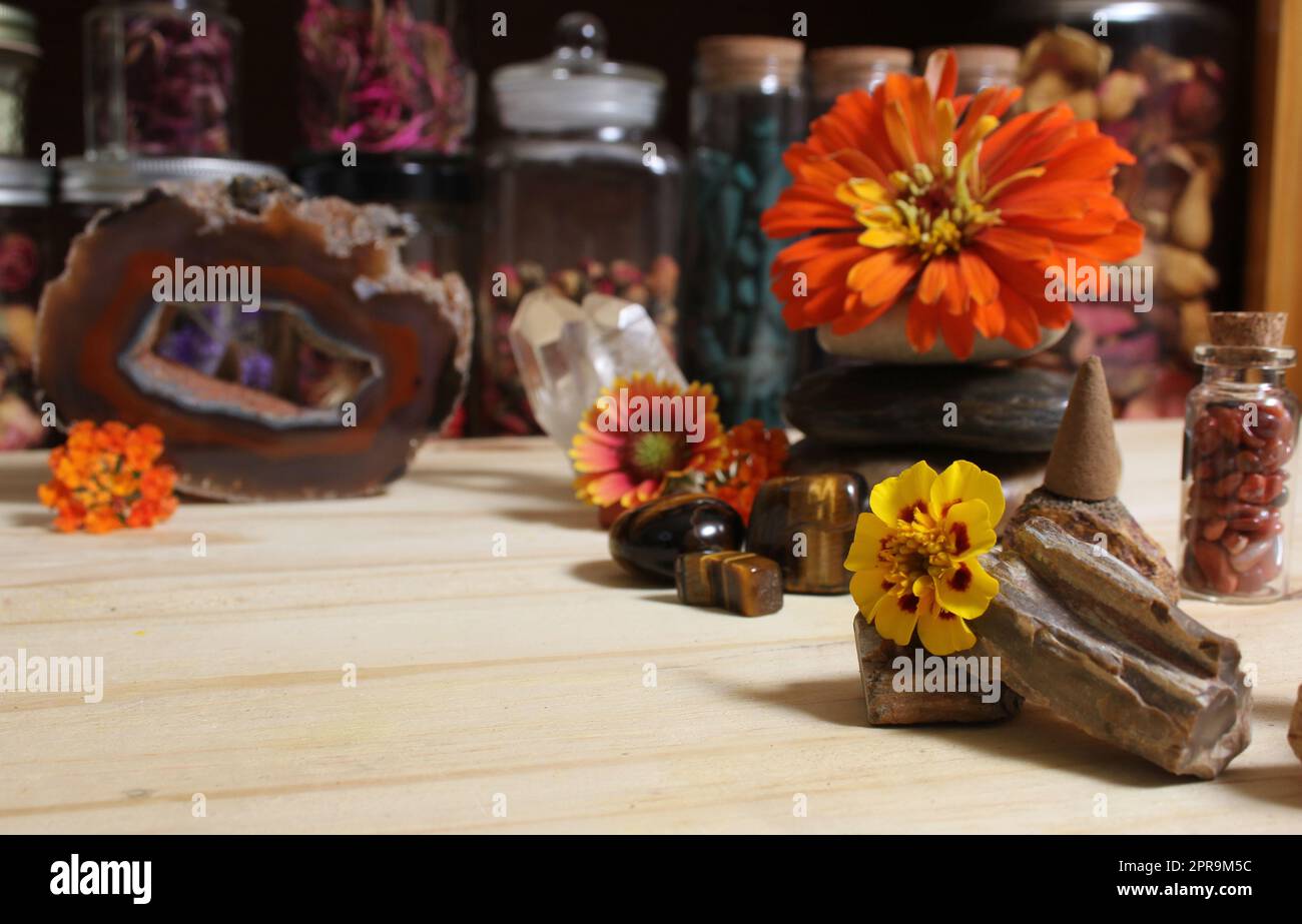 Agatized Coral mit Quarz-Kristallen und Blumen auf dem Meditationstisch Stockfoto