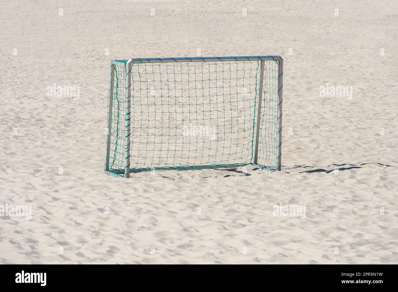 Fußball und Handballtor mit Netz auf Sand. Horizontales Sportposter, Grußkarten, Kopfzeilen, Website und App Stockfoto