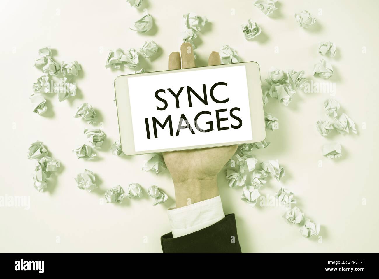 Handschrift Text Sync Images (Bilder synchronisieren). Unternehmensübersicht Fotos auf allen Geräten identisch machen überall zugänglich Papier wird unter dem Telefonbildschirm mit wichtiger Nachricht eingewickelt. Stockfoto