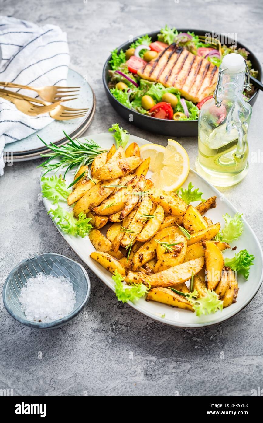 Kartoffelsplitter, im Ofen geröstet mit gemischtem Salat und gegrilltem Käse Stockfoto