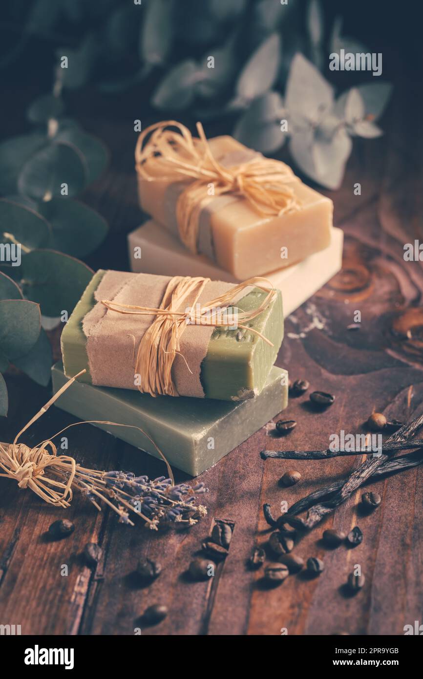 Natürliche Bio-Seifenstücke mit Vanille, Kaffeebohnen und Eukalyptus auf Holzhintergrund Stockfoto