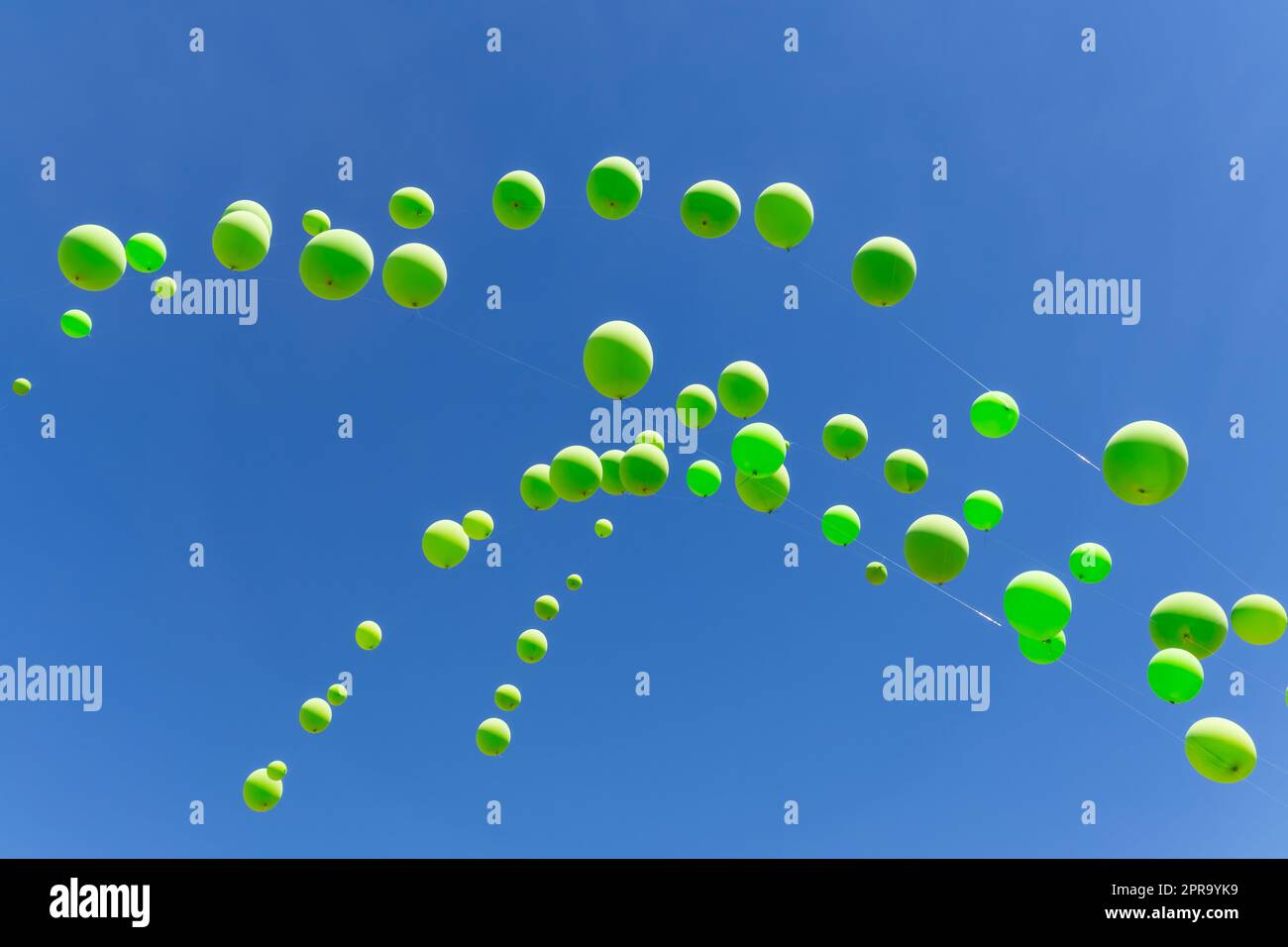 Grüne Ballons an einem blauen Himmel Stockfoto