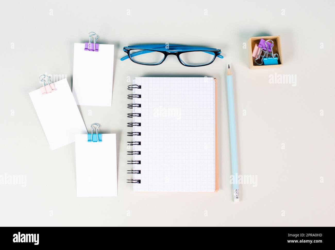 Leeres Notizbuch mit Stift, Papier und Brille auf grauem Hintergrund, Ideenfindung, Schreiben einer Botschaft, Arbeitsplatz-Schreibtisch, Home Office Stockfoto