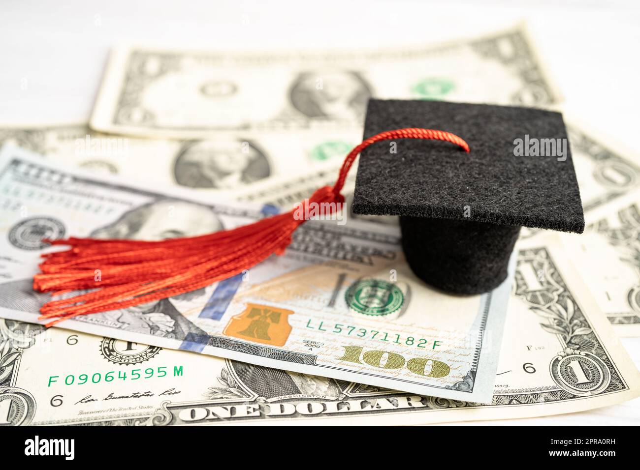 Graduation GAP hat auf US-Dollar-Banknoten Geld, Bildung Studiengebühr Lernen Lehre Konzept. Stockfoto