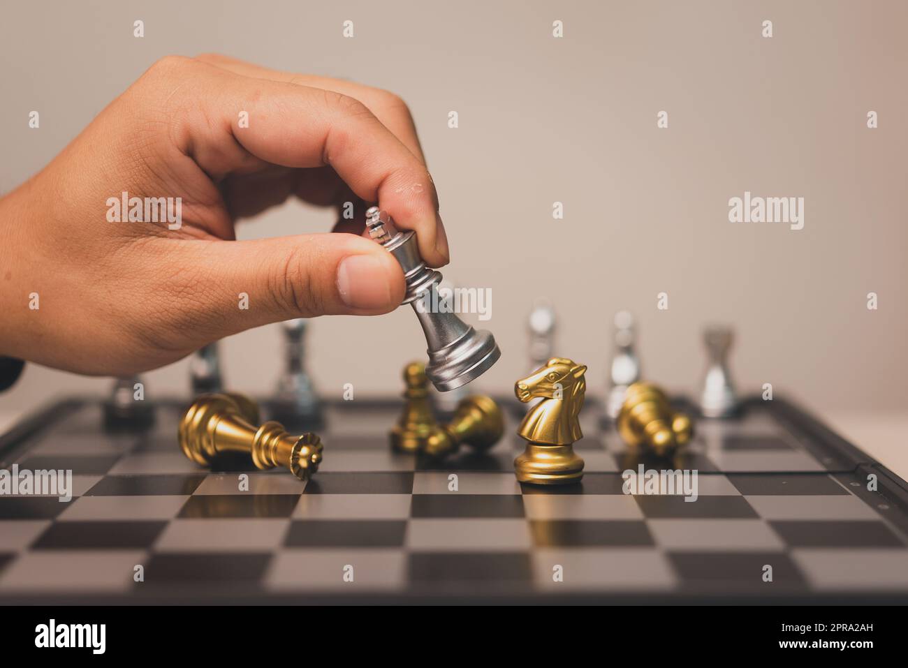 Hand Mann hält Schachspiel stehen auf Schachbrett.Geschäftsstrategie Teamwork Erfolg Anlagekonzept. Stockfoto