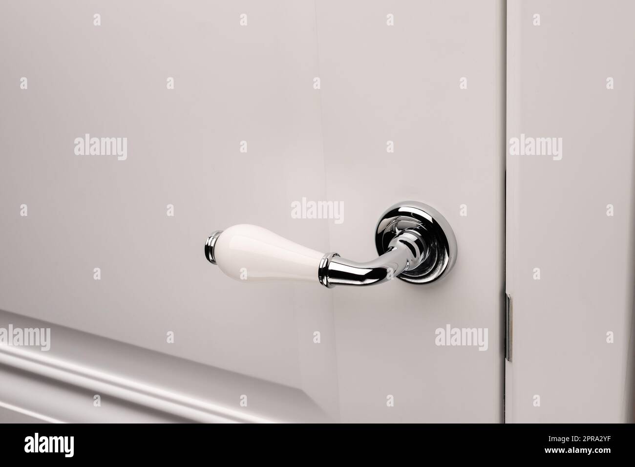 Nahaufnahme des eleganten Türknopfs oder -Griffs an der weißen Tür. Stockfoto