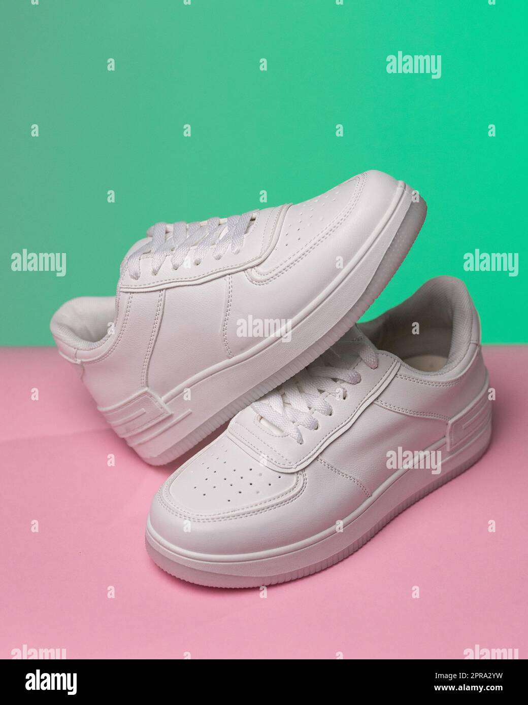 Werbefoto eines neuen weißen Sneakers für Damen oder Jugendliche mit farbigem Hintergrund. Stockfoto