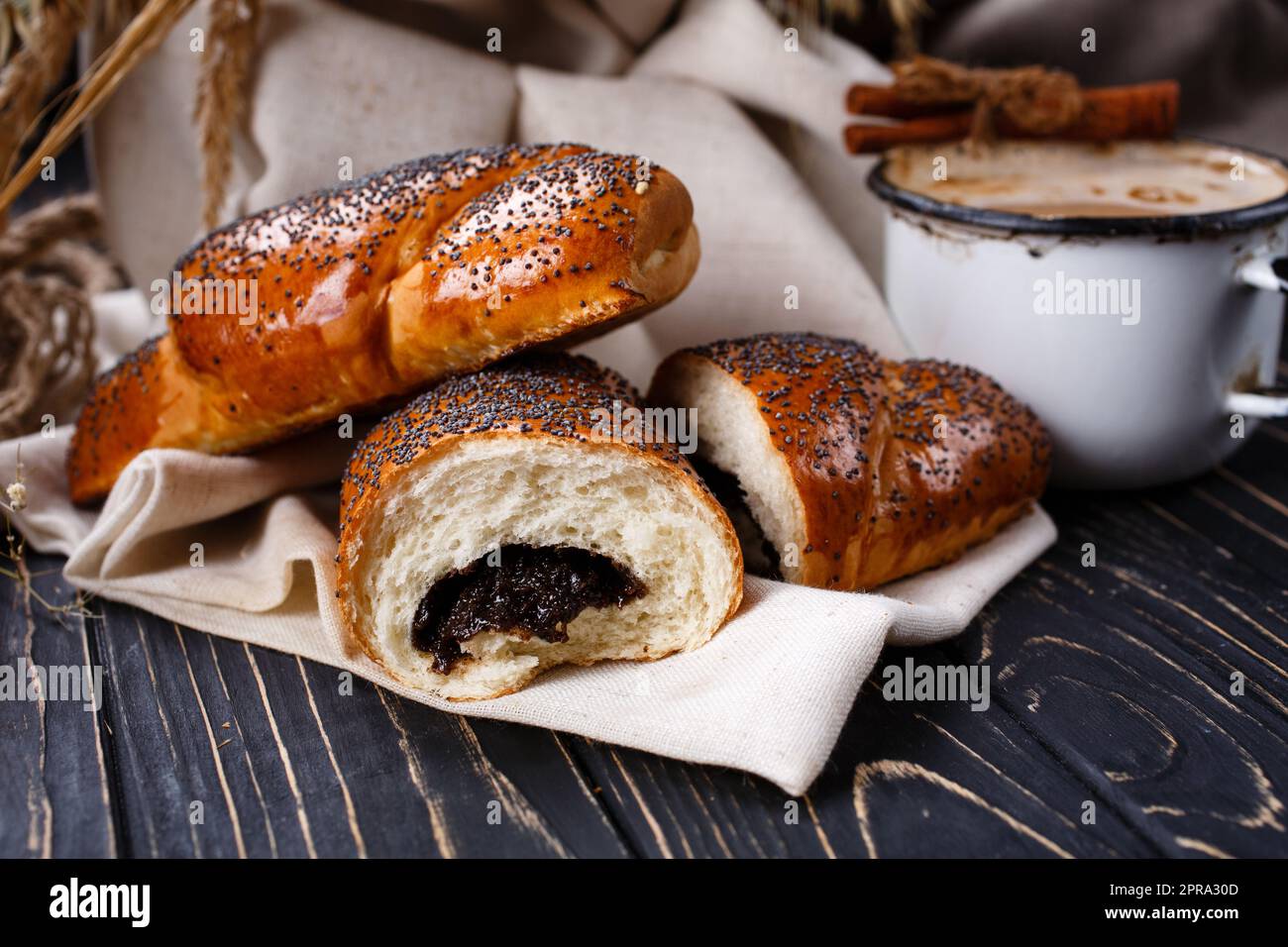 Frisch gebackene duftende hausgemachte Brötchen mit Marmelade auf rustikalem Holztisch. Stockfoto