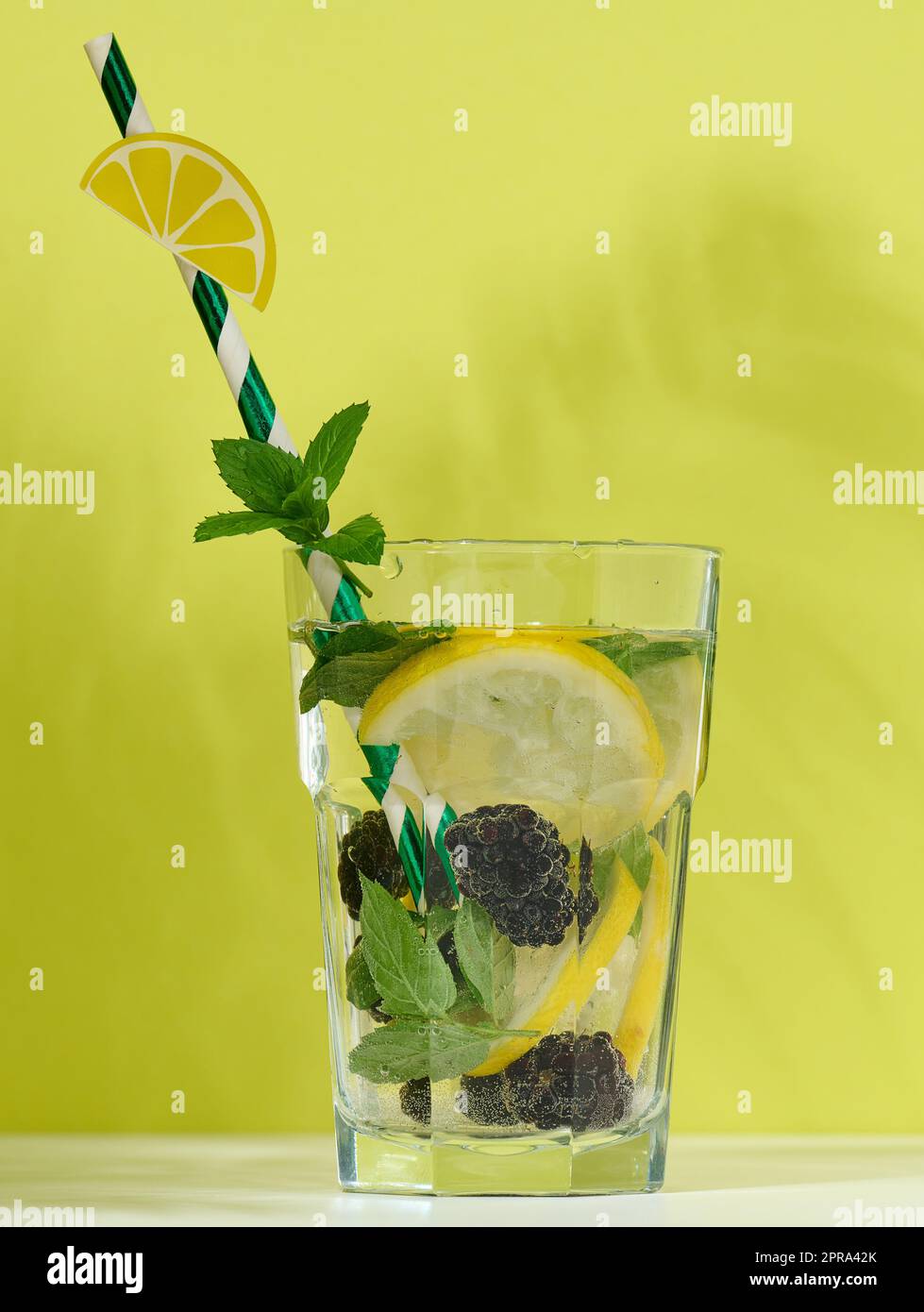 Transparentes Glas mit Limonade, Minzeblättern, Zitronenscheiben und Brombeeren Stockfoto